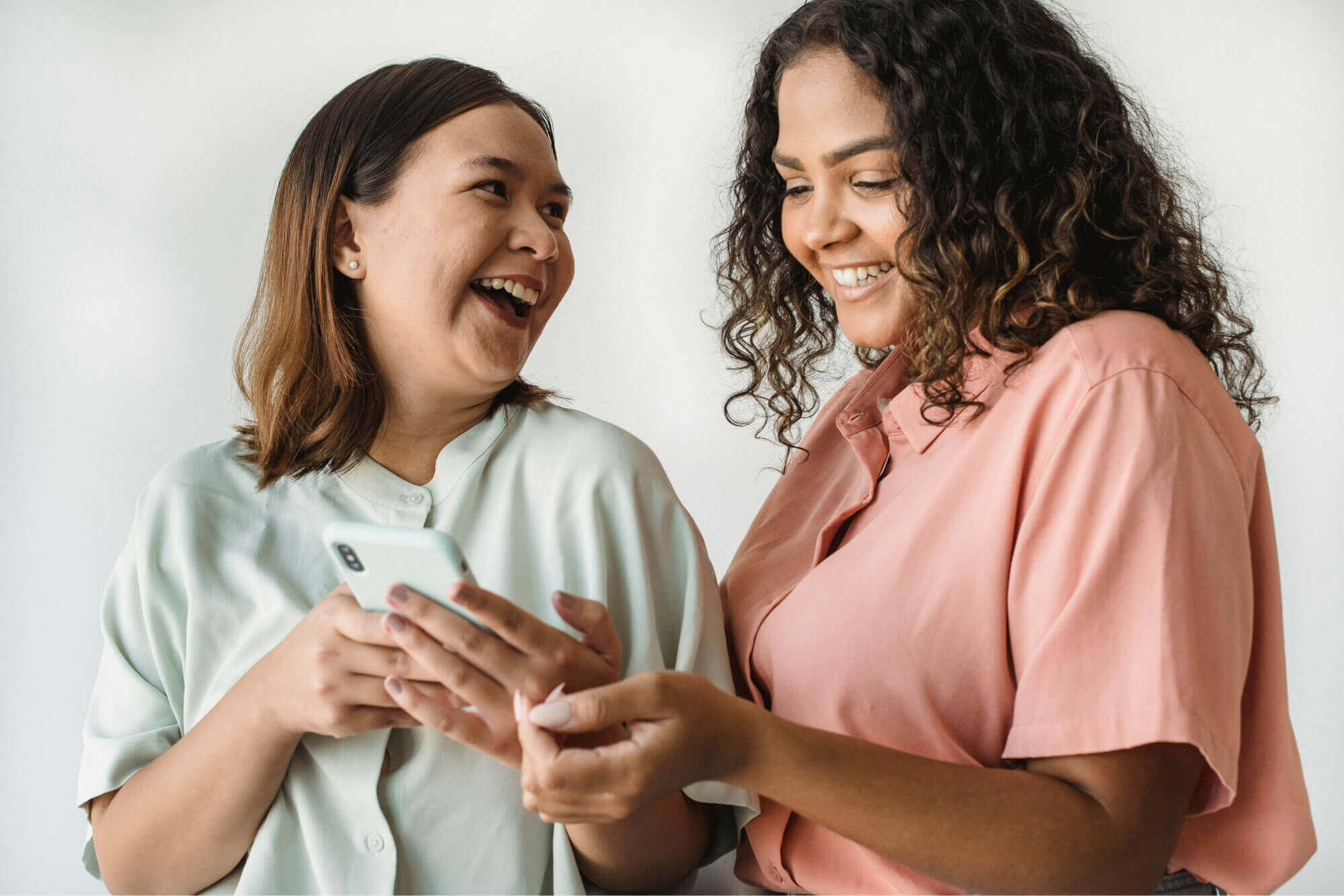 Two happy women with a phone.